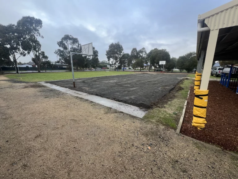 Image of concrete sports court base in progress with clear skies in the background.